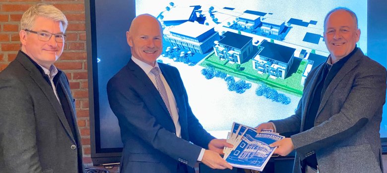v.l.n.r. Architekt Jorn Kick und Vorstand der Raiffeisenbank Handewitt, Niederlassung der VR Bank Westküste, Martin Rudolph übergeben den Bauantrag an Bürgermeister Thomas Rasmusssen für den geplanten Neubau